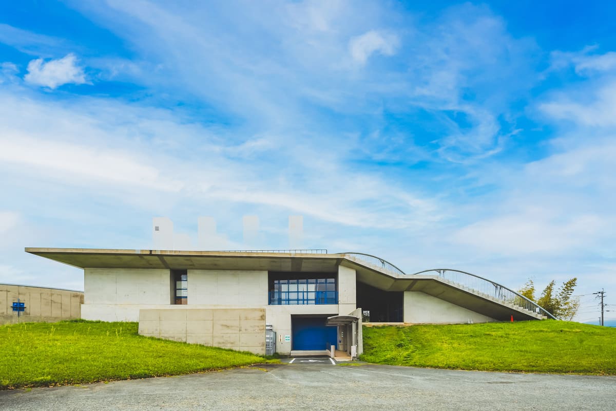 アーチ屋根を背負う建物の正面。青い扉が並ぶ